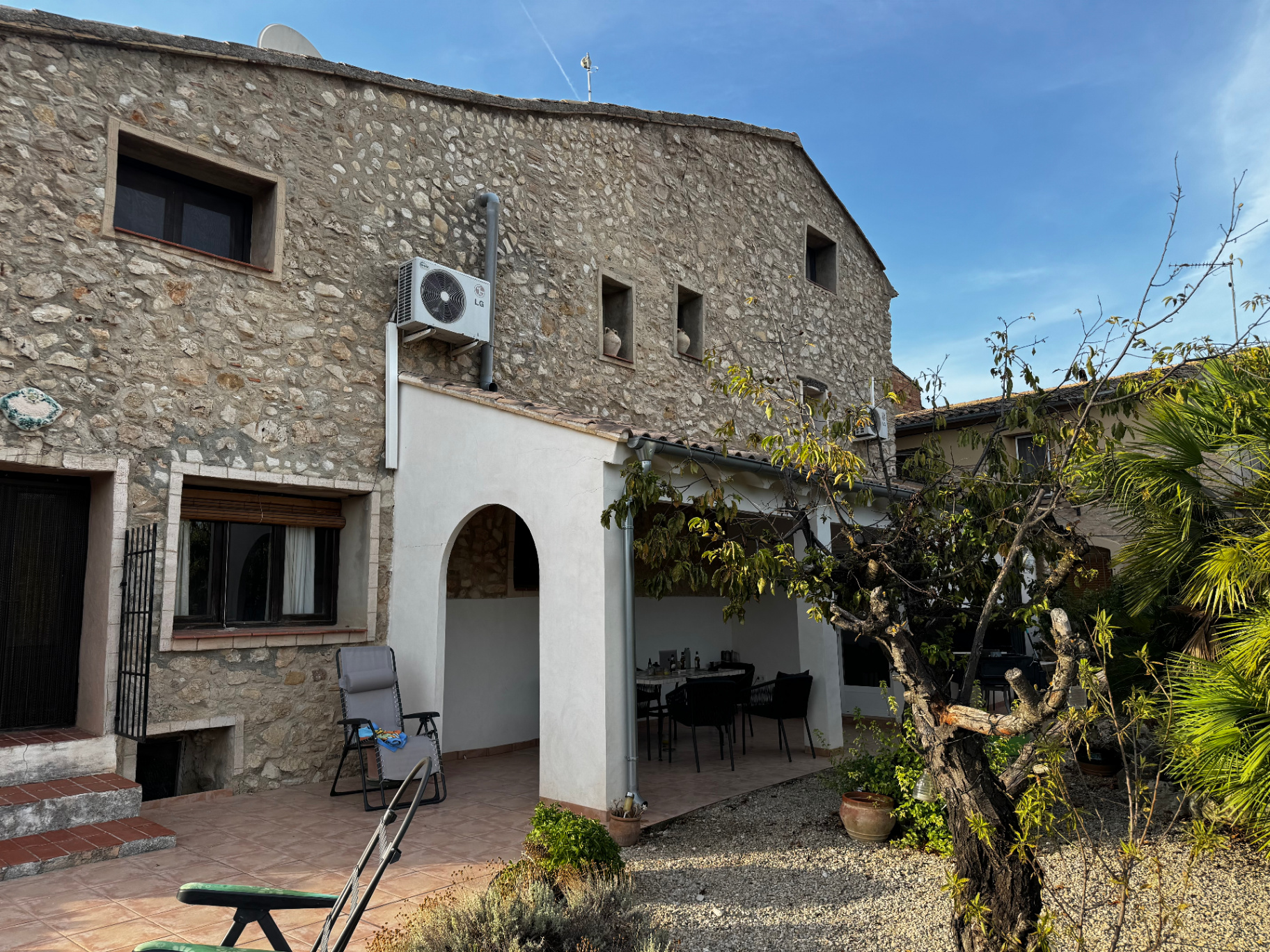 The stone side of Casa Piedra with its arched, shaded dining porch and gravel garden